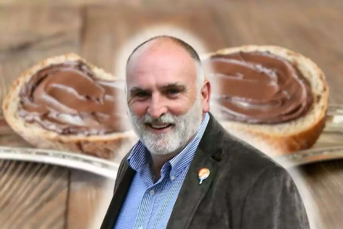 José Andrés somrient amb barba i jaqueta davant d'un fons de pa amb crema de xocolata.