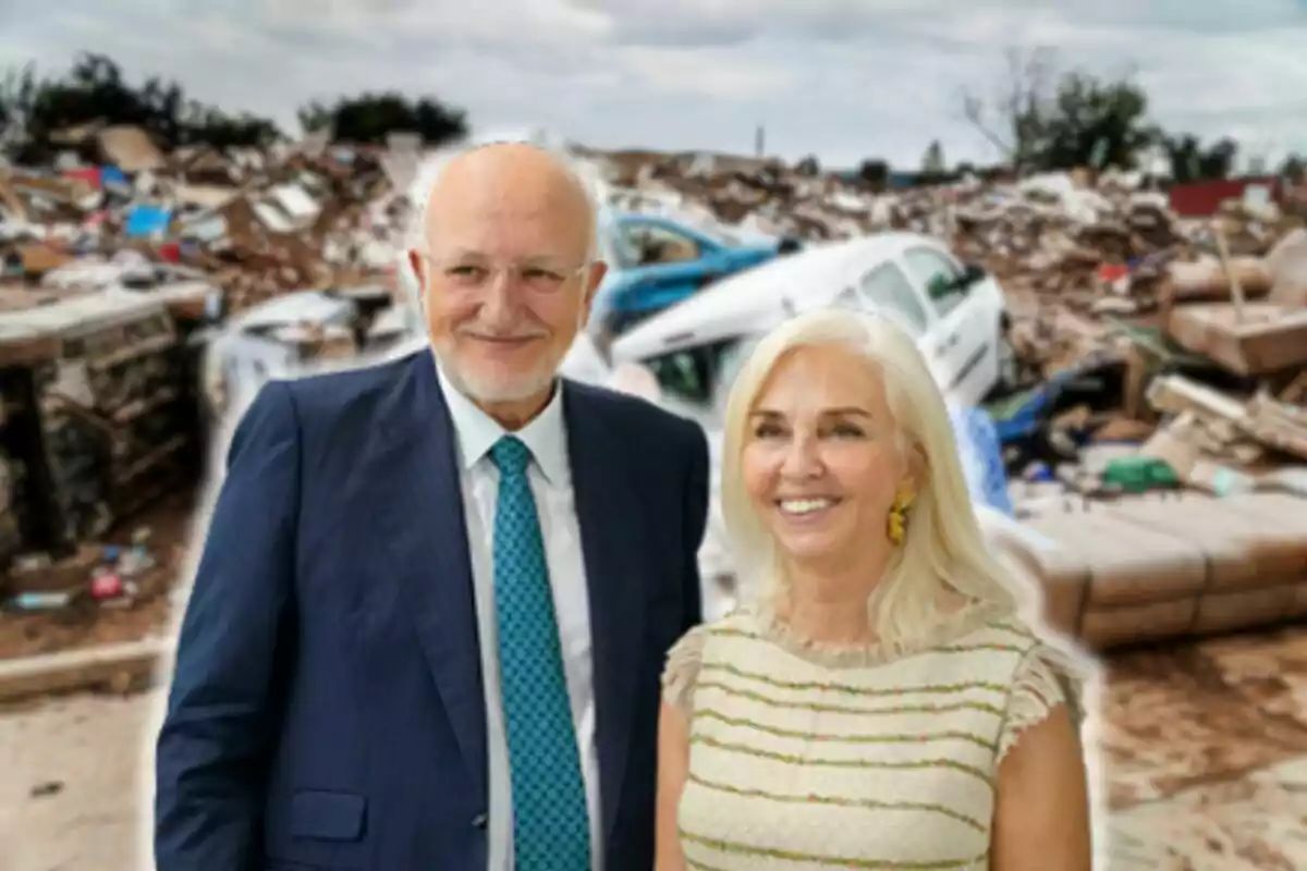 Juan Roig i Hortensia Herrero somrient posa davant d'un fons de runa i vehicles danyats.