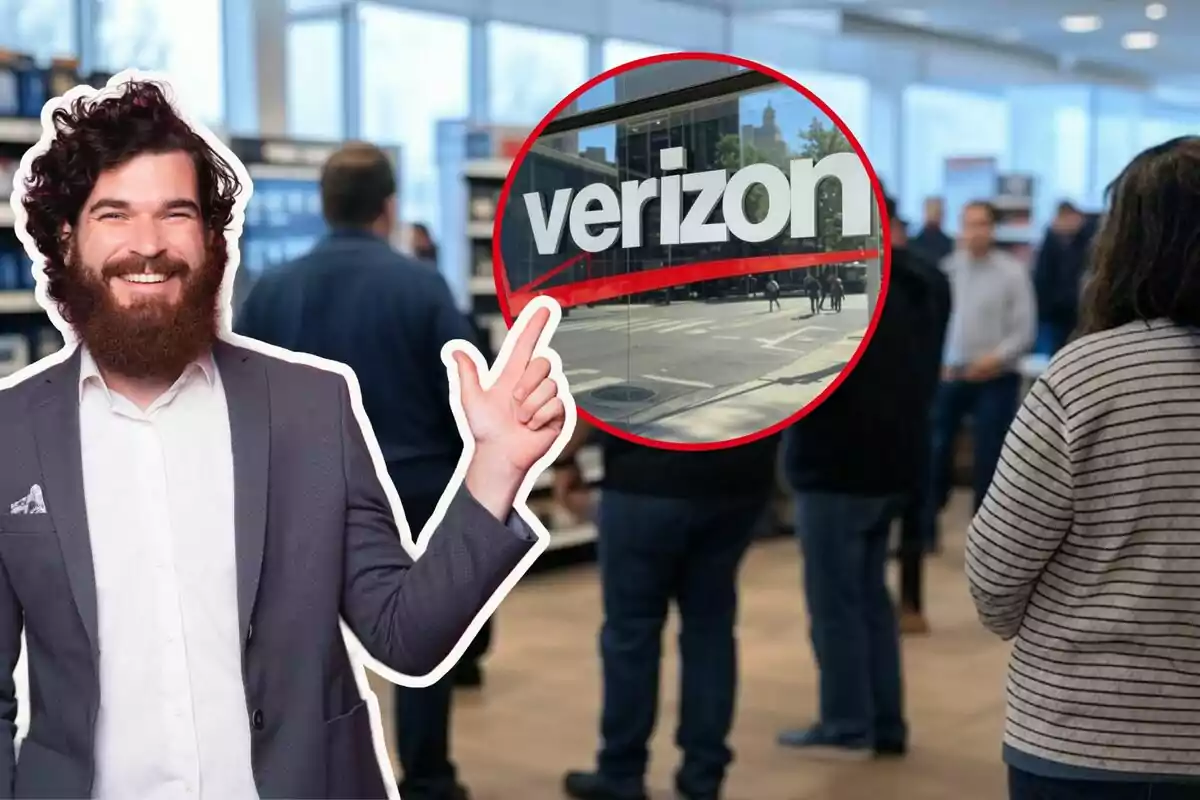 A smiling man with a beard and suit points to a Verizon logo in a store setting with several people in the background. A smiling man with a beard and suit points to a Verizon logo in a store setting with several people in the background.
