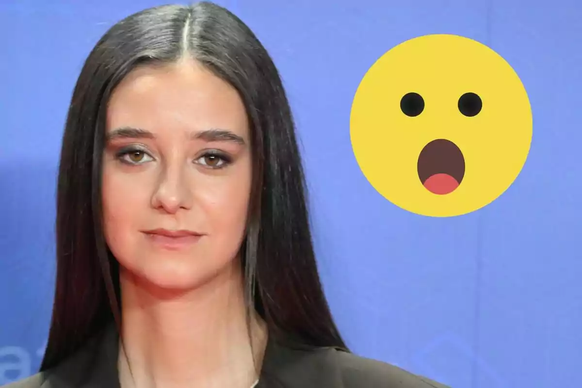 Victòria Federica amb cabell llarg i llis davant d'un fons blau amb un emoji de cara sorpresa al costat.