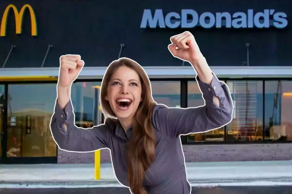 Smiling young woman enthusiastically raising her arms in front of a McDonald's restaurant