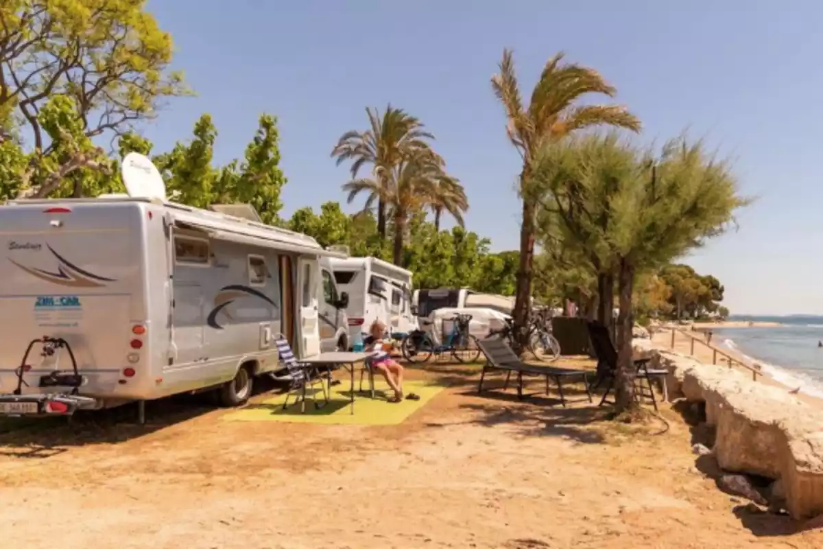 Autocaravana davant de la platja amb el mar Autocaravana davant de la platja amb el mar