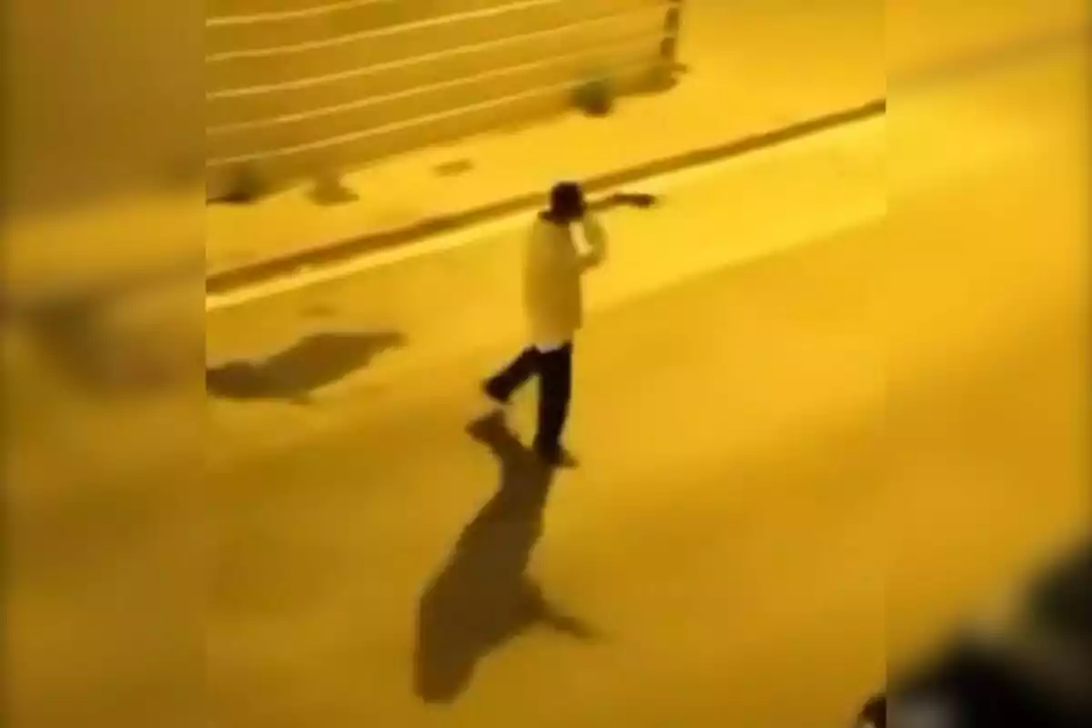 Una persona caminando por una calle desierta durante la noche.