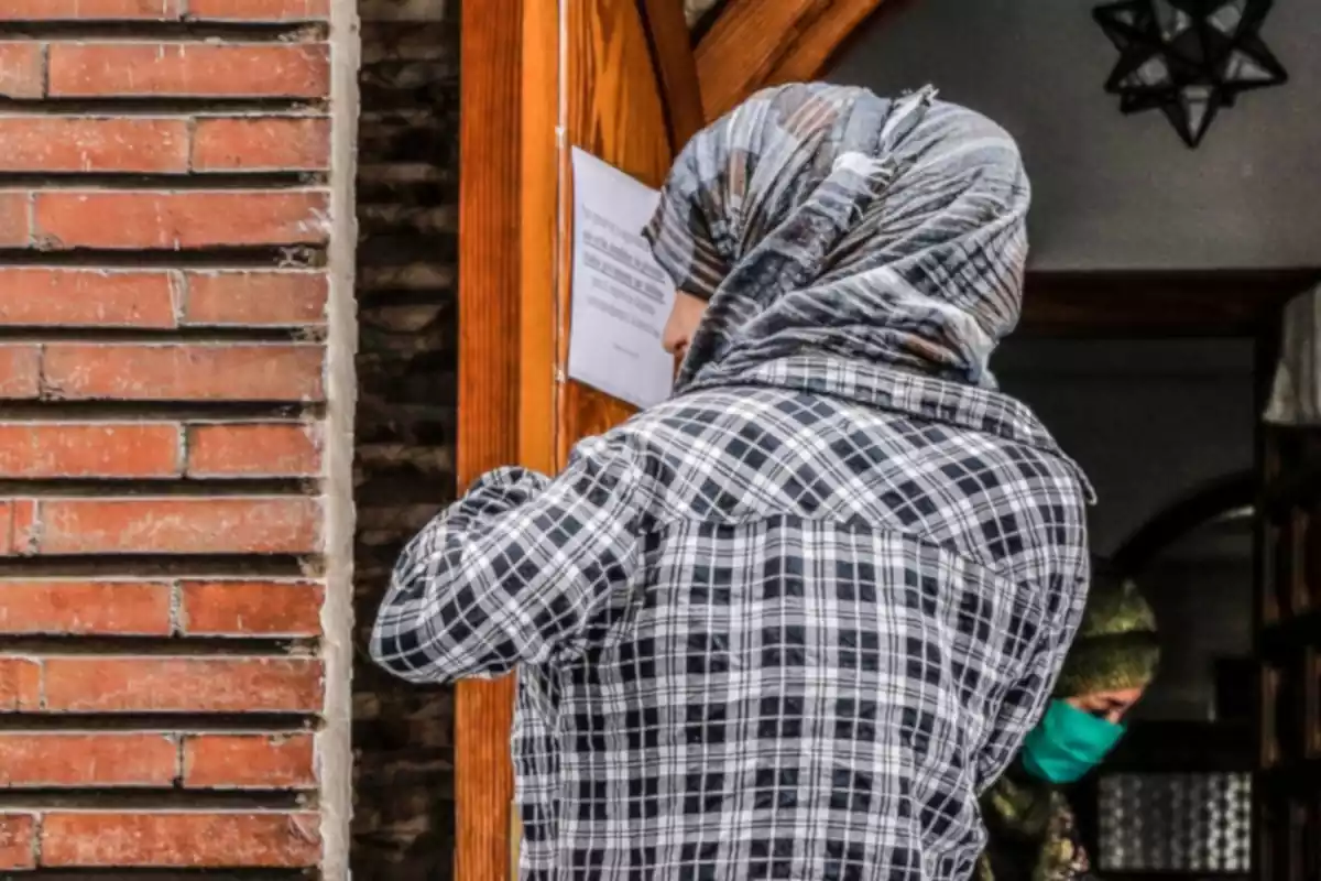 Una dona musulmana afectada per la crisi acudeix a la mesquita situada al carrer Méndez Núñez, 47, per recollir menjar que prèviament ha estat donat, a una setmana que s'acabi el període de Ramadà per als musulmans