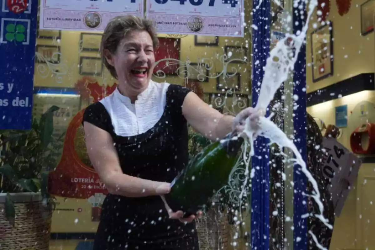 Una dona saltant de joia celebrant que ha guanyat la loteria amb cava