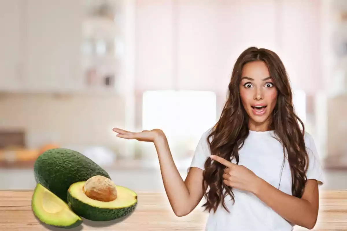 Mujer sorprendida señalando un aguacate en una cocina.