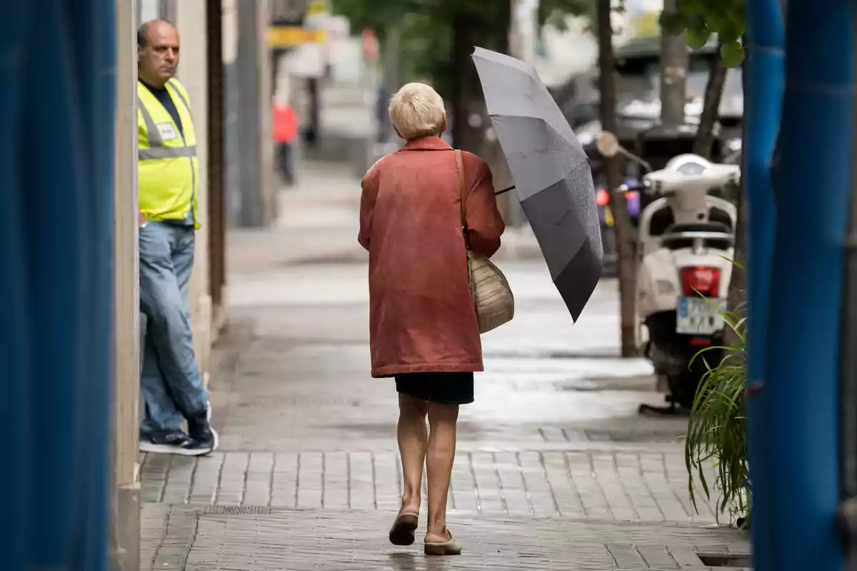 Una dona passeja per un carrer amb un paraigua, el 21 de maig de 2023, a Madrid. Una dona passeja per un carrer amb un paraigua, el 21 de maig de 2023, a Madrid.