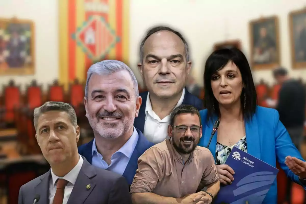 Cinc homes i una dona posen davant d’un fons borros d’una sala amb cadires vermelles i una bandera catalana.