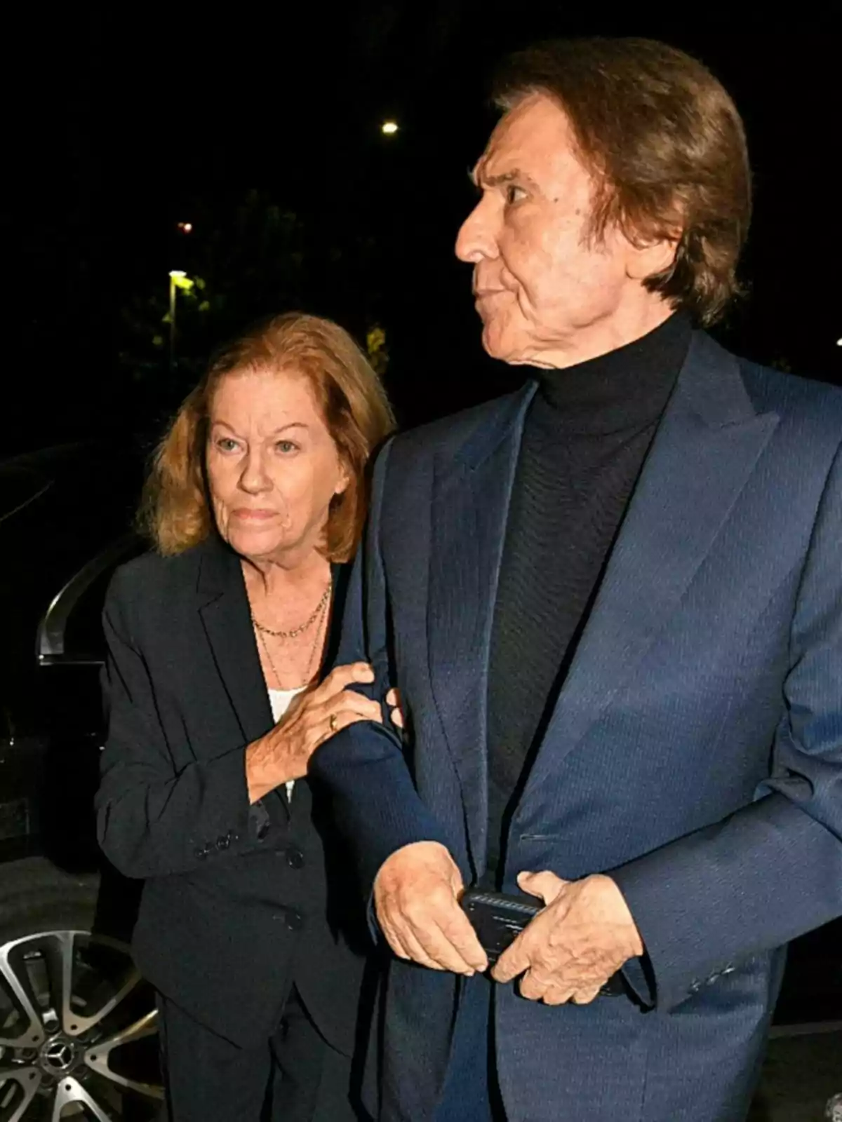 Natalia Figueroa and Raphael, elegantly dressed, walk together at night. Natalia Figueroa and Raphael, elegantly dressed, walk together at night.