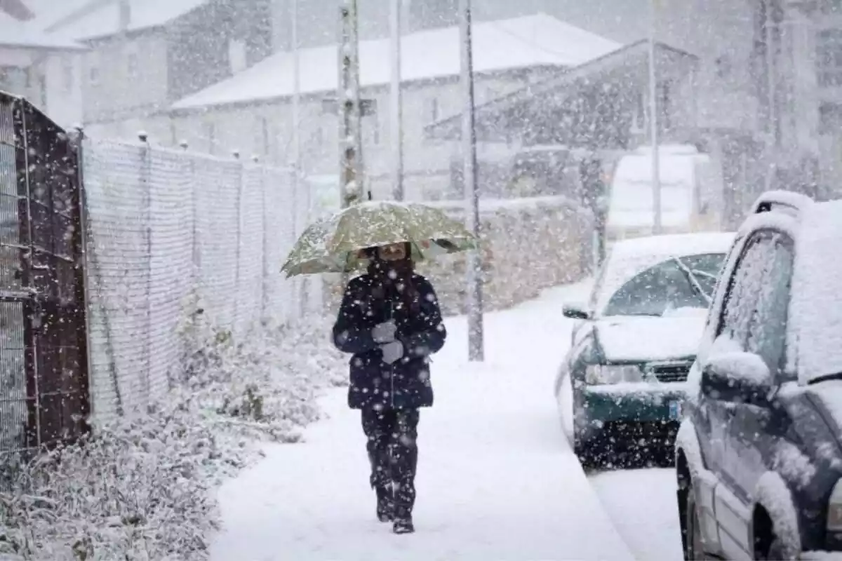 Imatge d'una persona caminant per un carrer de Pedrafita do Cebreiro, el 5 de gener de 2024, durant una nevada