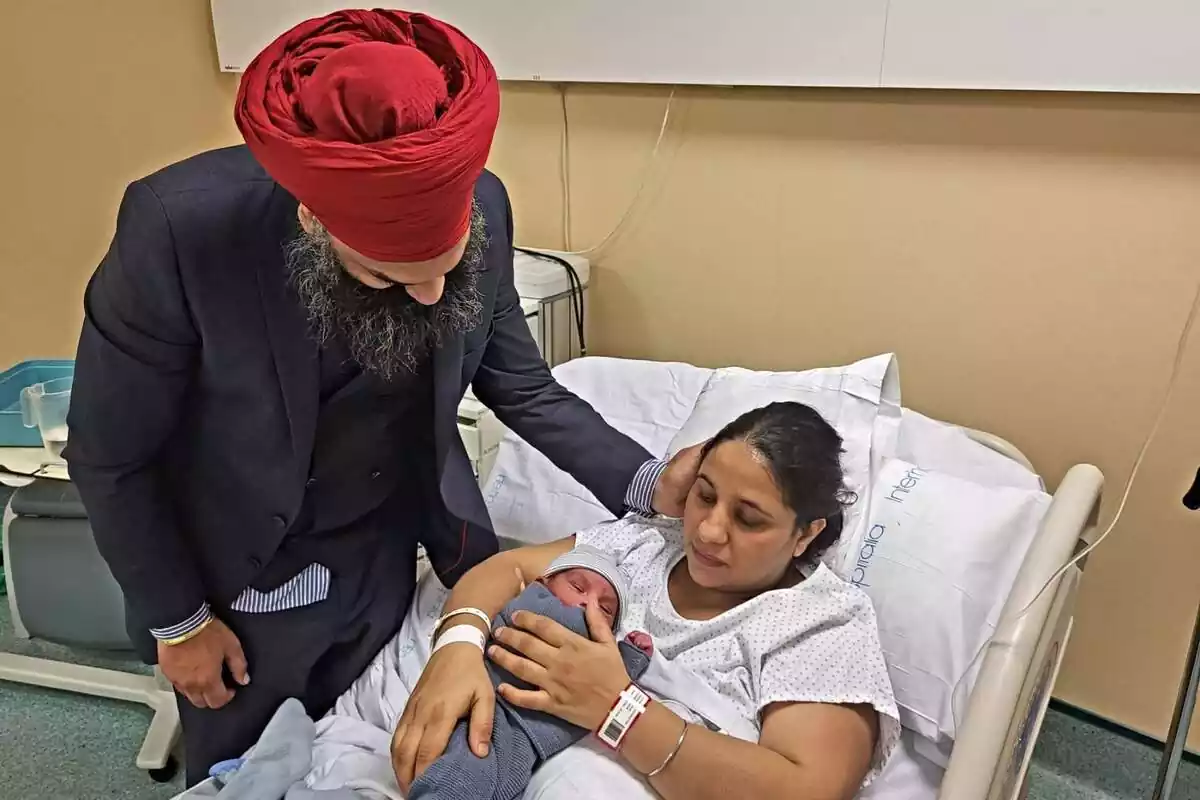 Rupindar Kaur i Amrik Singh en una habitació de l'hospital de Figueres amb el seu nen recent nascut als braços de la mare