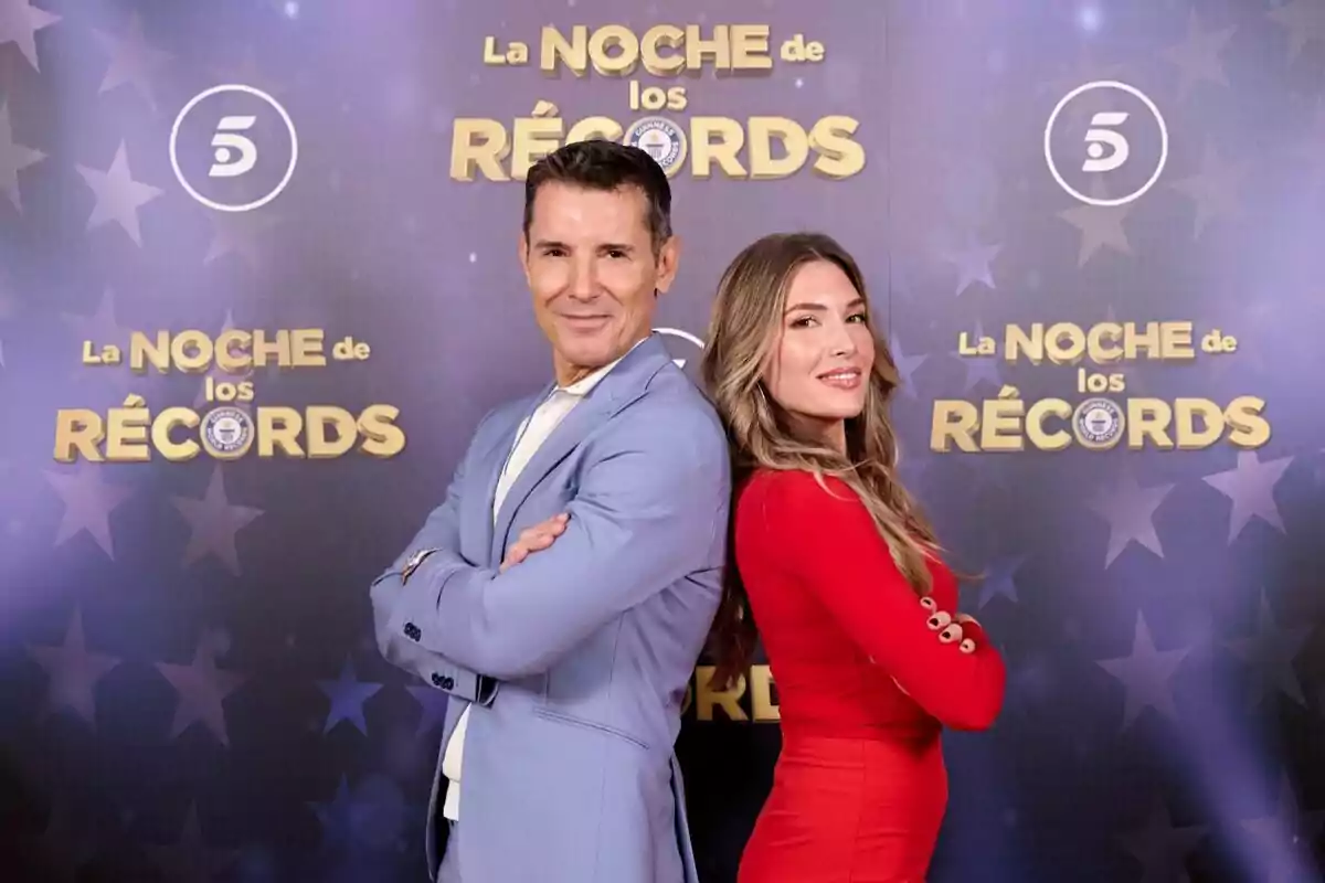 Jesús Vázquez i Álex Blanquer posen d'esquena en un esdeveniment anomenat "La Nit dels Rècords" amb un fons decorat amb estrelles i logotips.