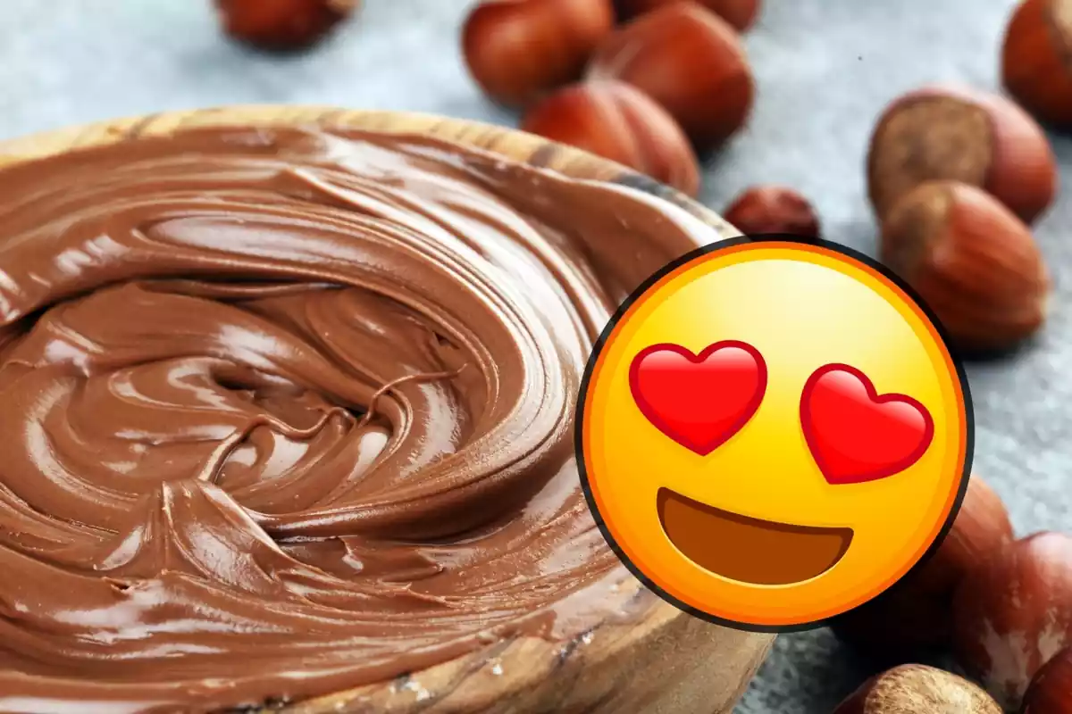 Emoji amb cors als ulls sobre imatge en pla al costat d'unes quantes avellanes de cintura de bol de fusta amb xocolata per untar tipus Nutella