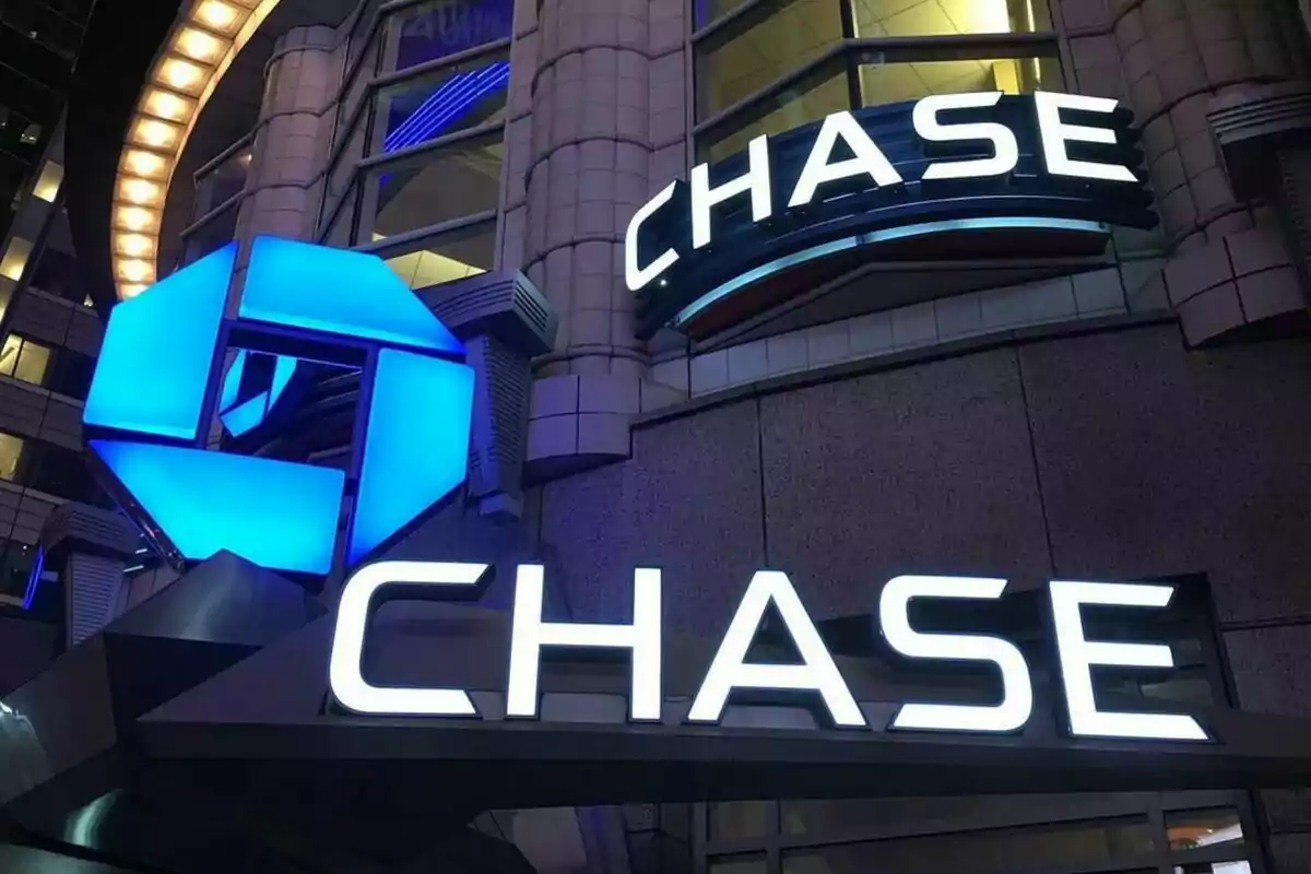 Una oficina del banc americà Chase Bank amb el logotip en blau i ben il·luminat de nit.