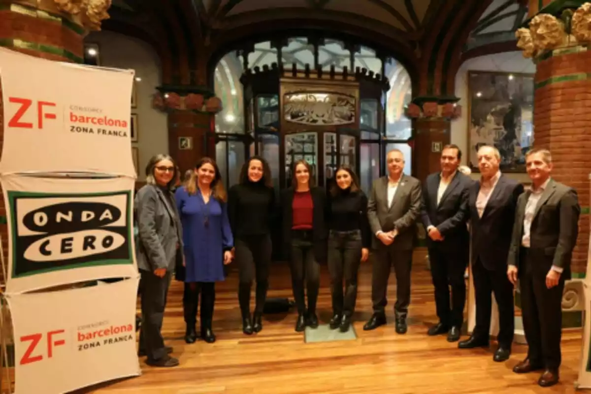 Un grupo de personas posando en un interior elegante junto a carteles de "Onda Cero" y "Consorci Barcelona Zona Franca".