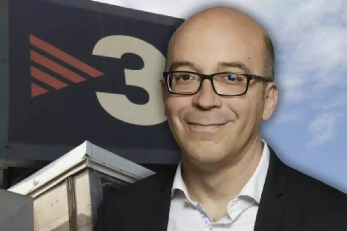 Un hombre con gafas y traje oscuro frente a un cartel con el número 3 y un logotipo.