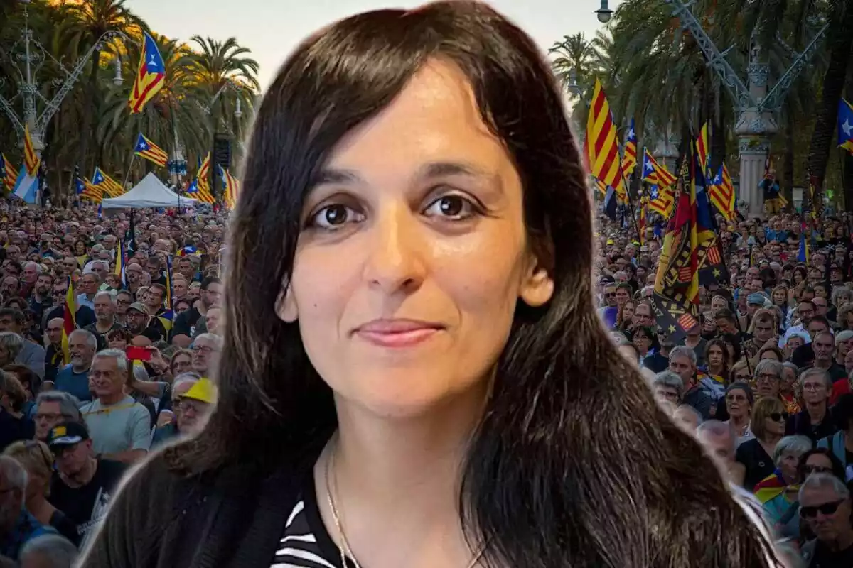 Primer pla de Sílvia Orriols amb la imatge d'una manifestació independentista de fons