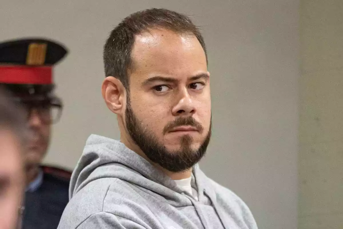 Pla curt de Pablo Hasel mirant de banda amb cara d'enfadat durant un dels seus judicis