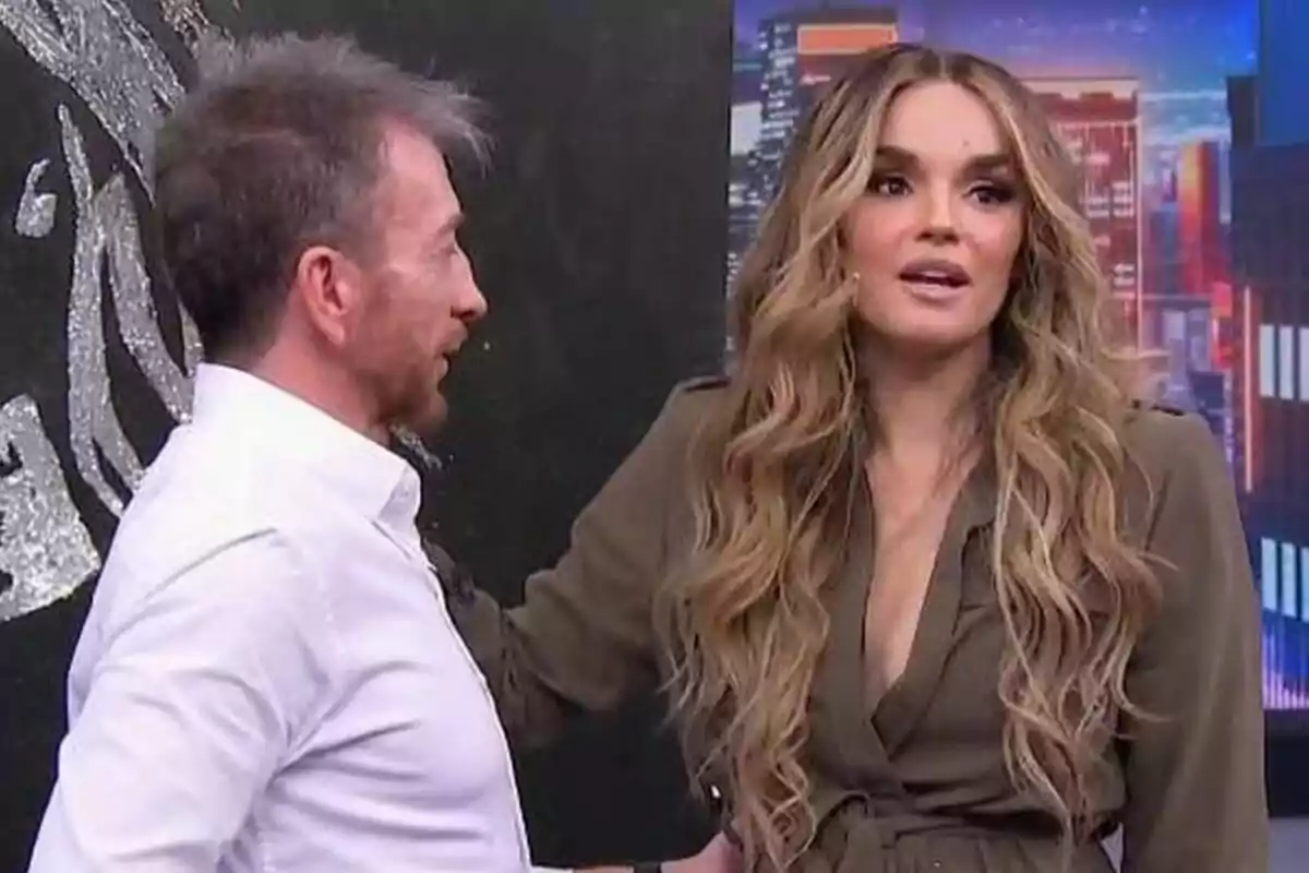 Pablo Motos i Melody conversen en un plató d’El Hormiguero amb un fons de ciutat il·luminada Pablo Motos i Melody conversen en un plató d’El Hormiguero amb un fons de ciutat il·luminada