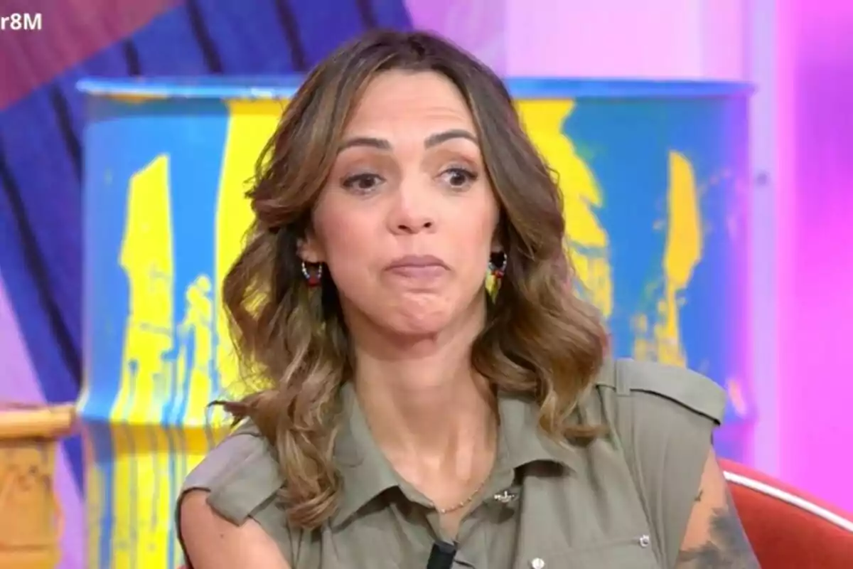 Paola Olmedo amb cabell castany i ondulat està asseguda davant d'un fons acolorit que inclou un barril pintat de blau i groc a 'Tardear'.