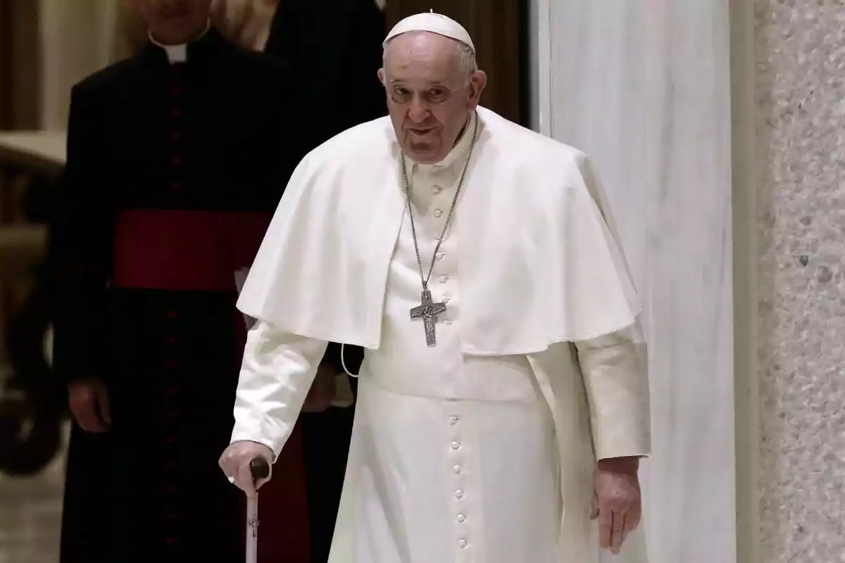 Plano medio del Papa Francisco andando con un bastón y con rostro sonriente.