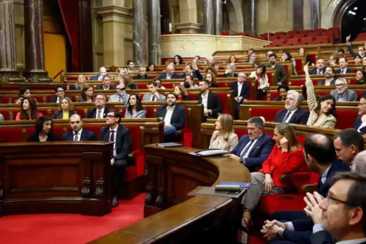 People seated in a hemicycle during a parliamentary session.