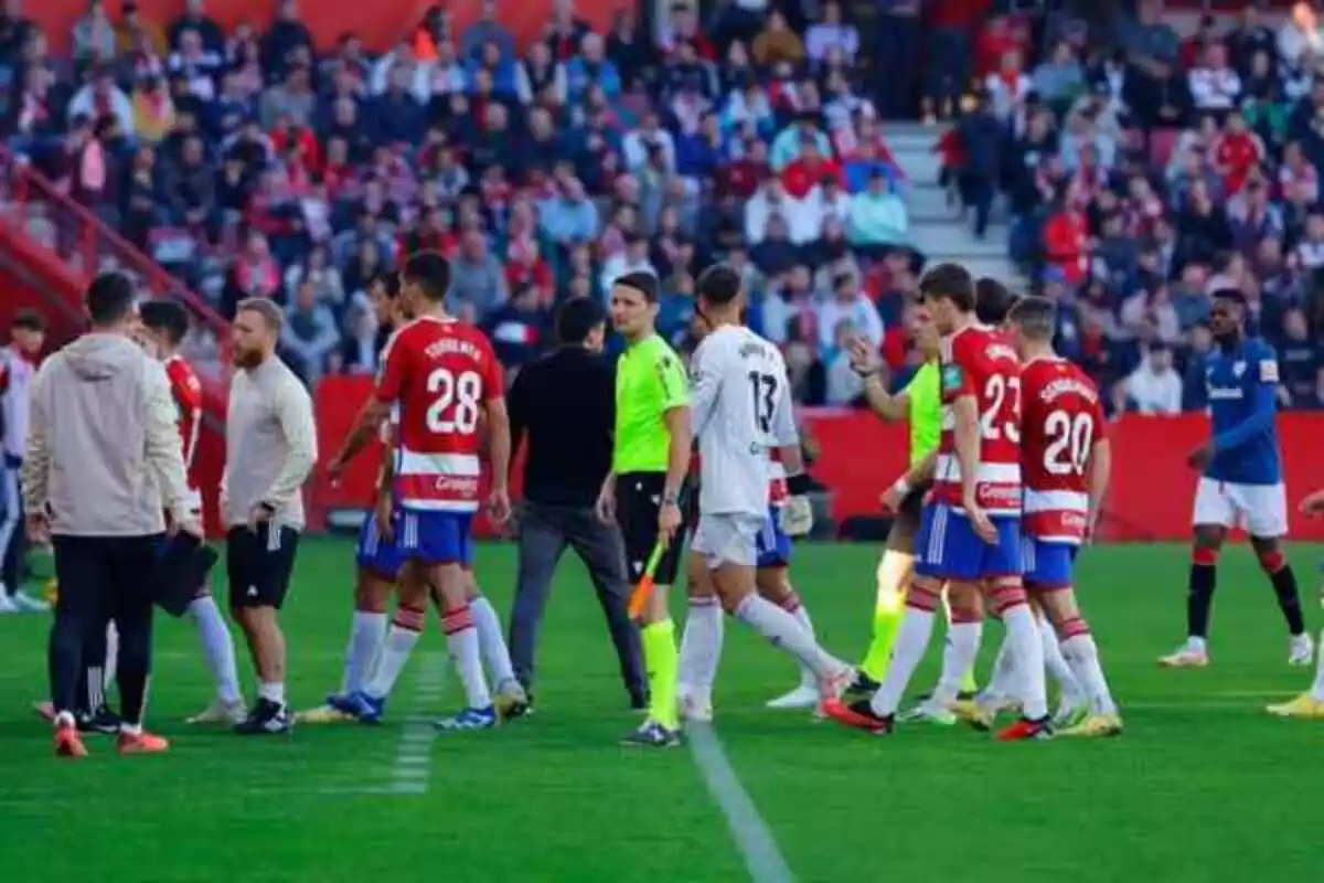 Jugadors de futbol de l'athletic i del Granada marxant cap al túnel de vestidors