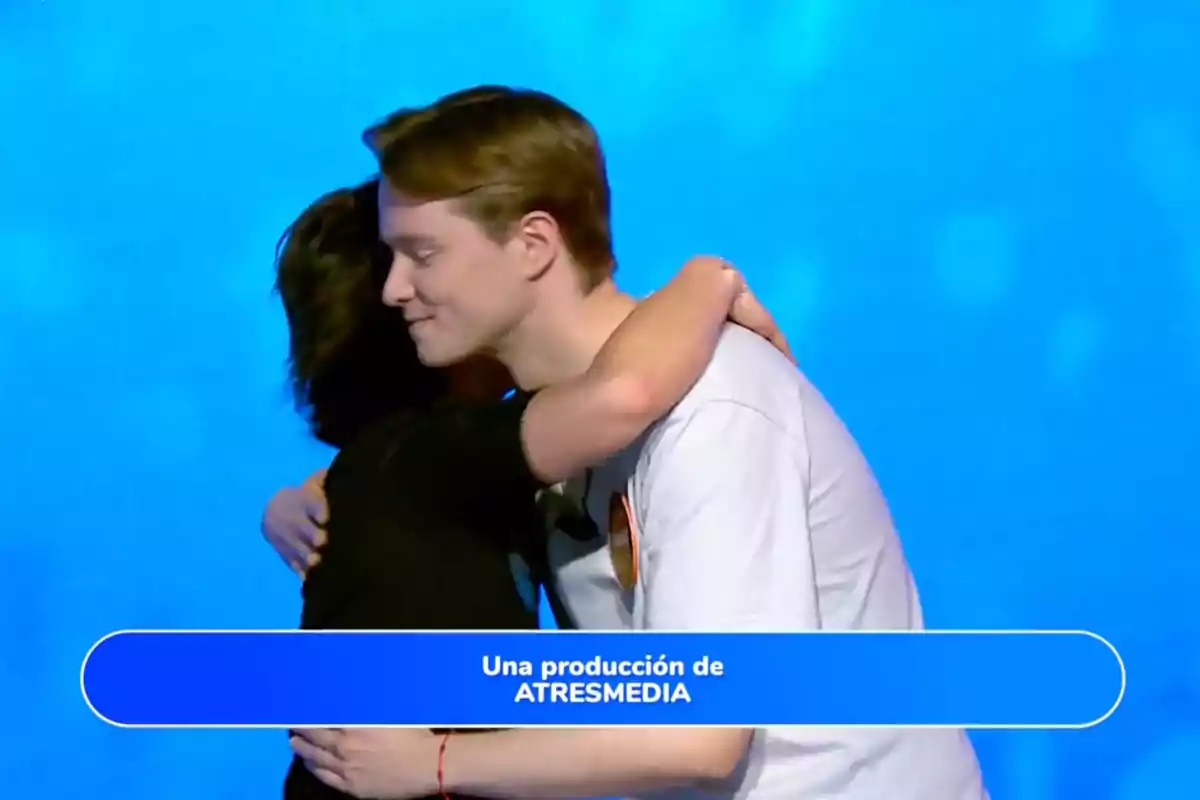 Rosa i Manu s’abracen davant d’un fons blau amb un requadre a la part inferior que diu una producció d’ATRESMEDIA. Captura de ‘Pasapalabra’ Rosa i Manu s’abracen davant d’un fons blau amb un requadre a la part inferior que diu una producció d’ATRESMEDIA. Captura de ‘Pasapalabra’