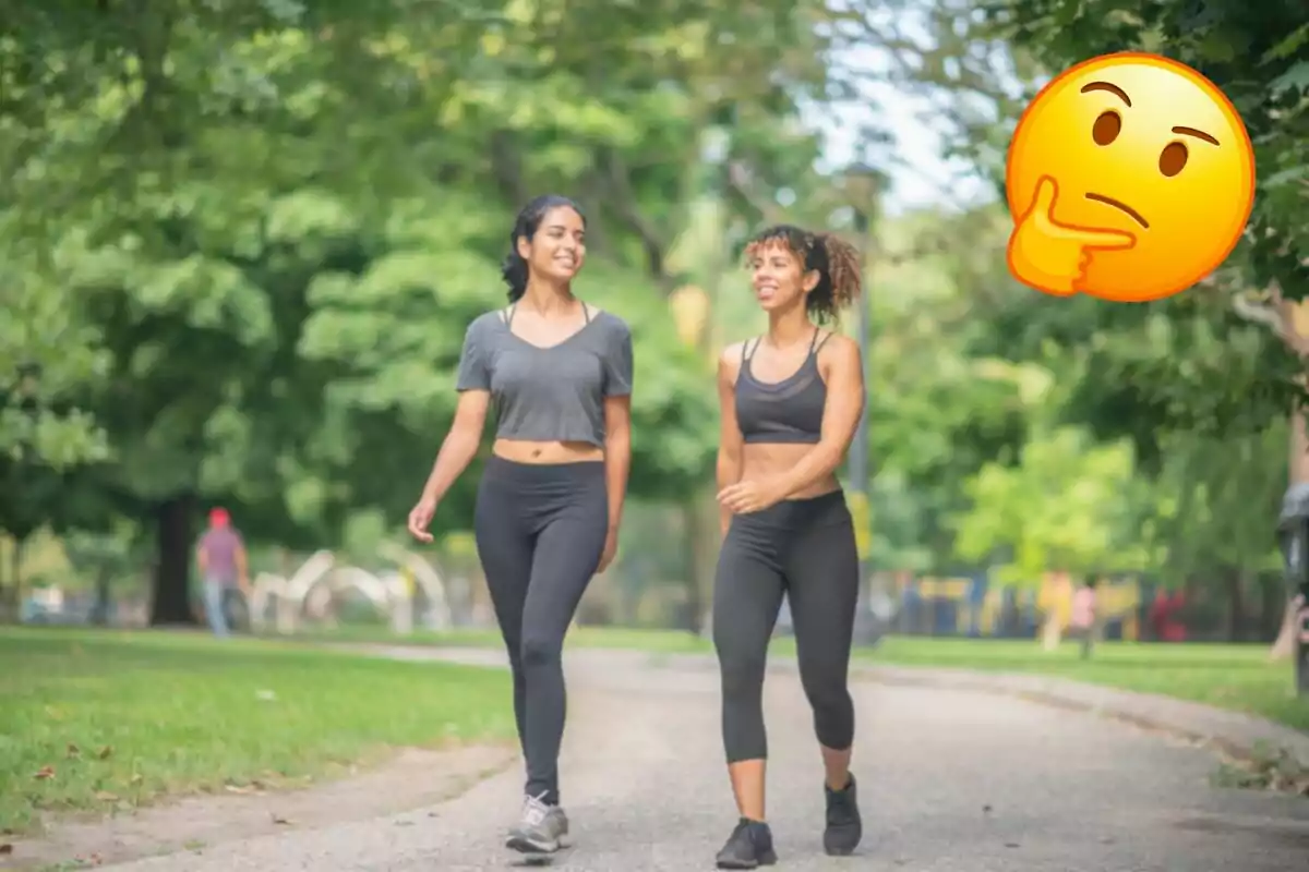 Two women walking in a park with a pensive emoji in the upper right corner.