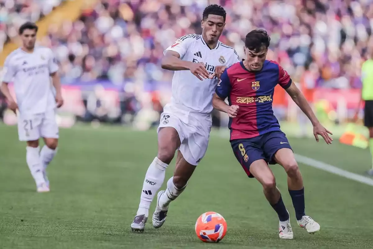 Two players compete for the ball in a match, one wearing white and the other wearing blue and red. Two players compete for the ball in a match, one wearing white and the other wearing blue and red.