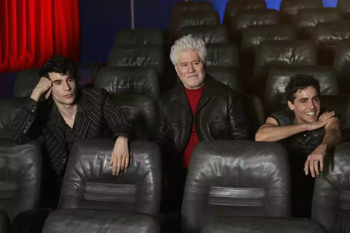 Pedro Almodóvar, Javi Calvo i Javi Ambrossi asseguts en una sala de cinema buida, un d’ells amb els cabells canosos i els altres dos més joves, cadascun amb una expressió diferent a Pedro x Javis.