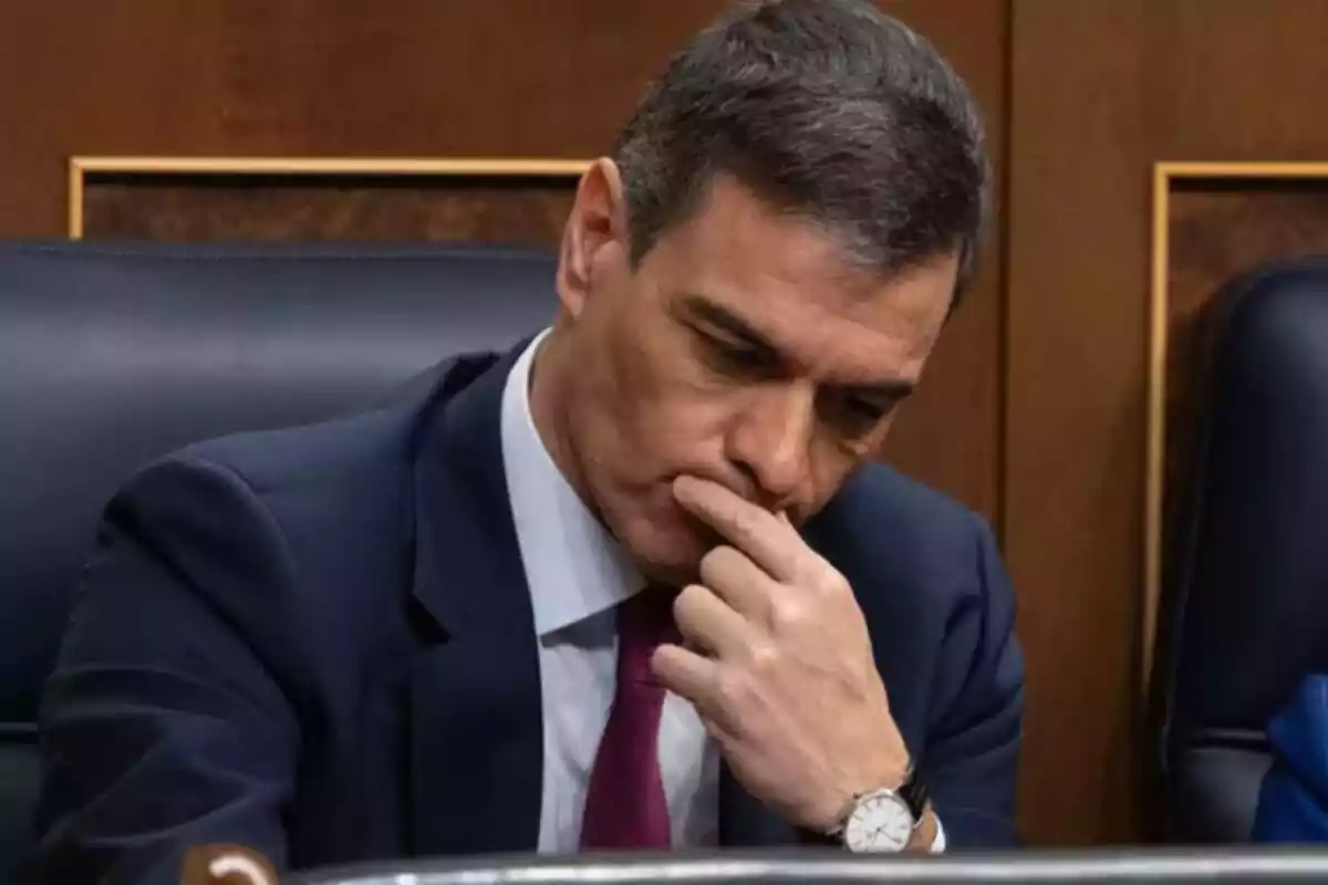 Pedro Sánchez assegut al congrés amb expressió pensativa i mirant cap avall