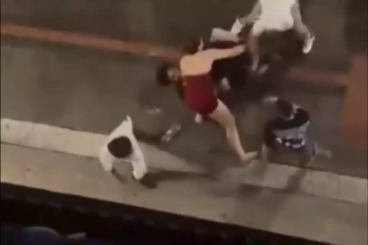 Diverses persones estan involucrades en una baralla al carrer durant la nit.