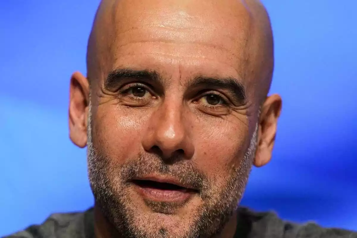 Primer pla de Pep Guardiola somrient i mirant a càmera