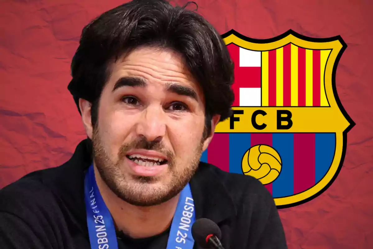 Dark-haired man speaking in front of a microphone with the FC Barcelona crest in the background