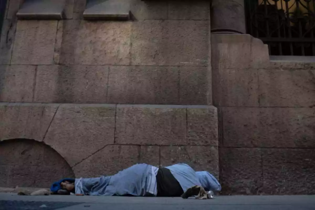 Una persona dorm al carrer, el 14 de desembre de 2023, a Barcelona, Catalunya