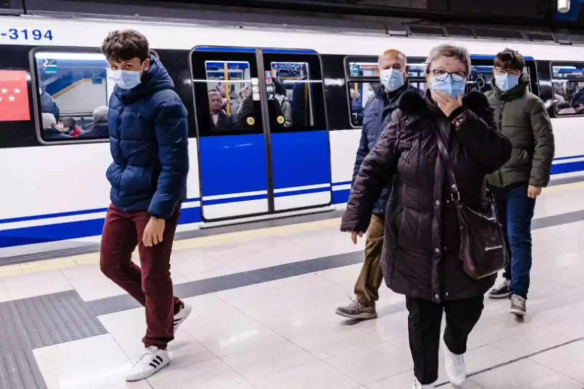 Diverses persones amb mascareta en una andana del Metro de Madrid