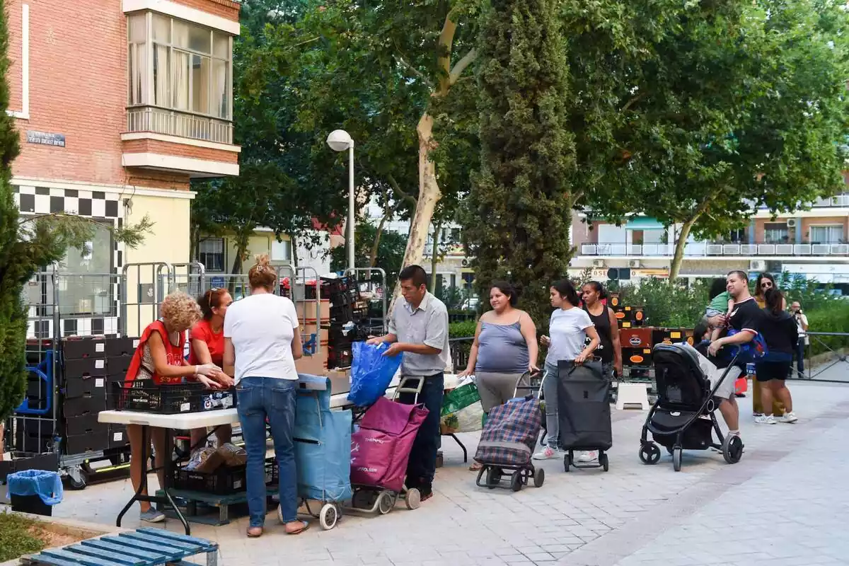 Diverses persones fan cua per rebre productes de primera necessitat donats, a la Plaça de Sant Amaro, a 16 d'agost de 2023, a Madrid (Espanya)