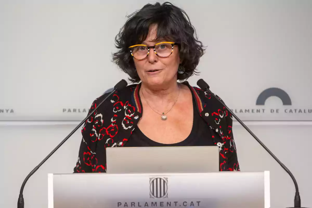 Dona amb ulleres parlant a un podi del Parlament de Catalunya.