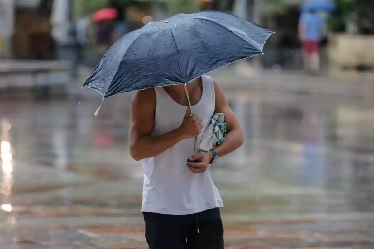 Imatge d'un home escapant-se de la pluja
