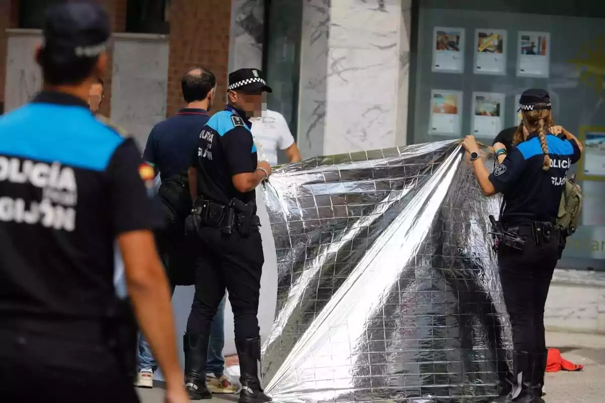 Policia Local de Gijón, tapant el cadàver d'un home assassinat