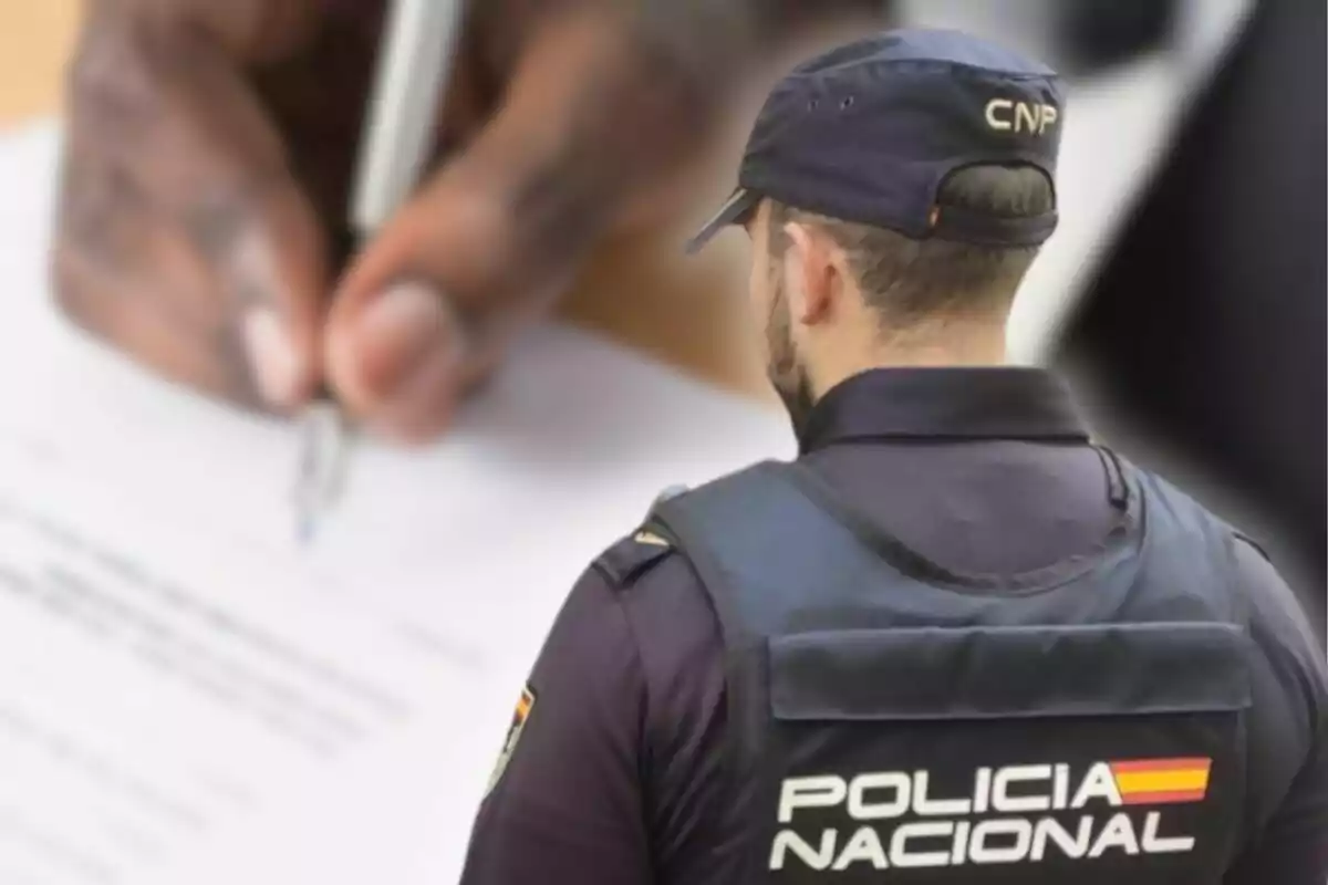 A National Police officer with his back turned observes a person writing on a document.