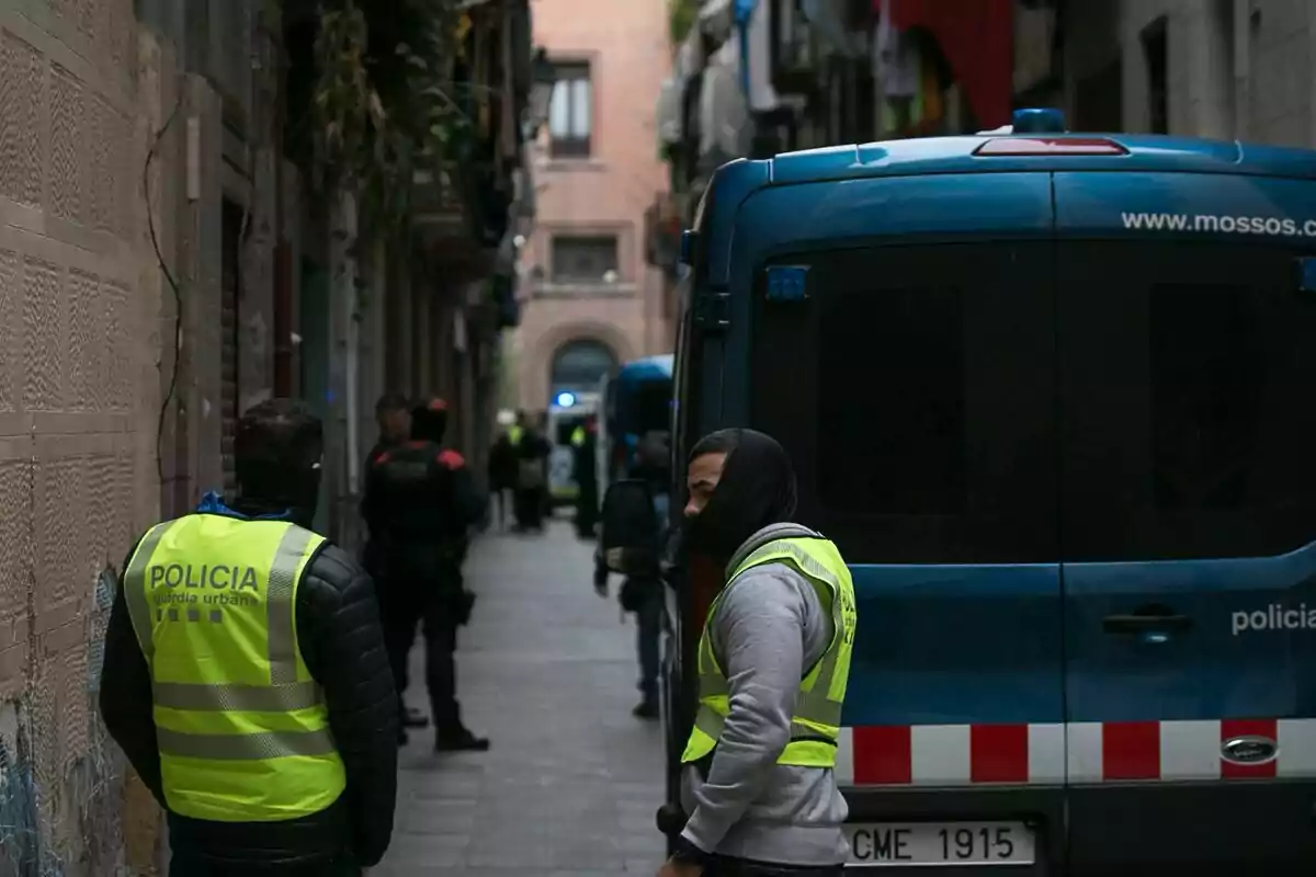 Agents de Mossos d'Esquadra i Guàrdia Urbana amb una dona detinguda després dels registres efectuats als "narcopisos" al "El Raval", al districte de Ciutat Vella de Barcelona.