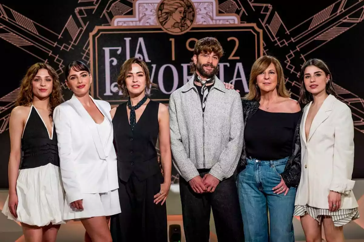 Elenco "La Favorita 1922" posando frente a un fondo decorativo, todos vestidos de manera elegante y casual.