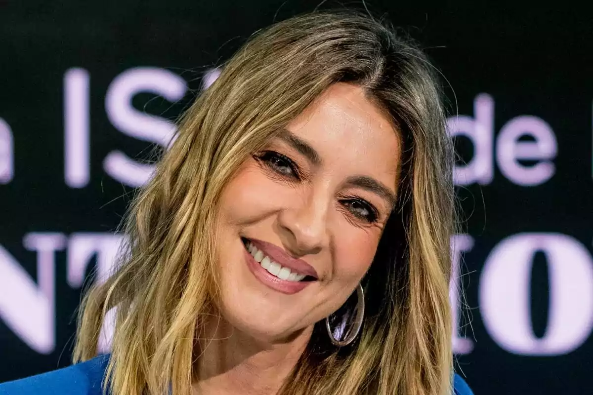 Sandra Barneda sonriendo con el cabello suelto y un fondo oscuro de La Isla de las Tentaciones.