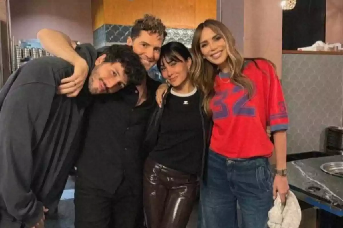 A group of four people posing together and smiling in an indoor setting. A group of four people posing together and smiling in an indoor setting.