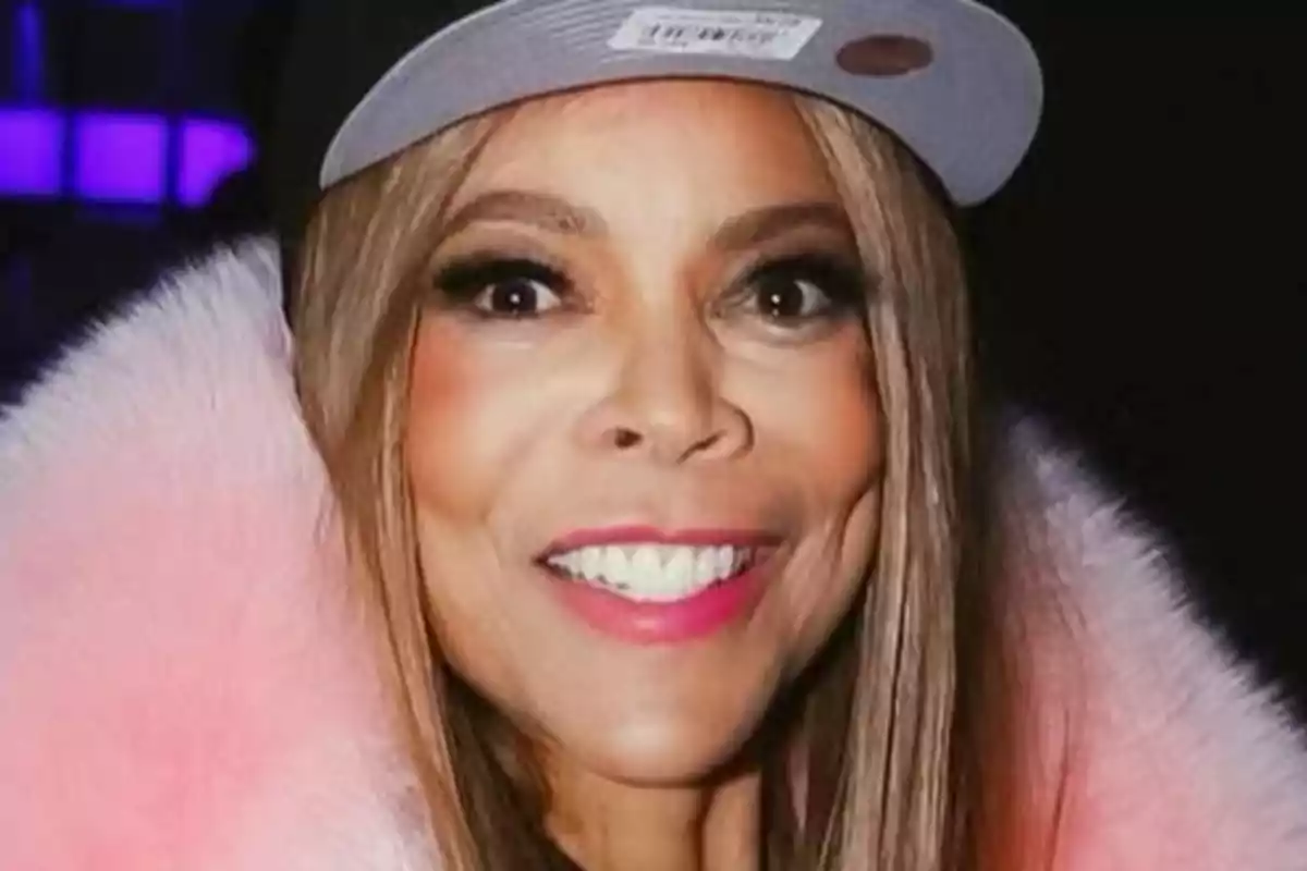 Wendy Williams somrient amb una gorra i un abric de pell rosa.