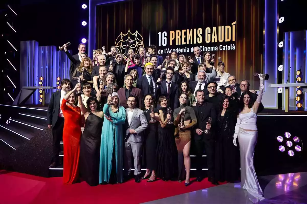 Foto de grup amb una treitena de premiats als Premis Gaudí lluint el seu trofeu a l'escenari on es va celebrar la gala
