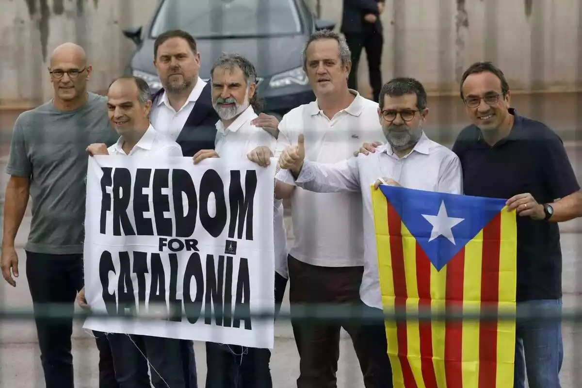 Pla americà de Raül Romeva, Jordi Turull, Oriol Junqueras, Jordi Cuixart, Joquim Forn, Jordi Sánchez i Josep Rull en sortir de la presó amb una estelada i una pancarta amb el lema 'Freedom for Catalonia'