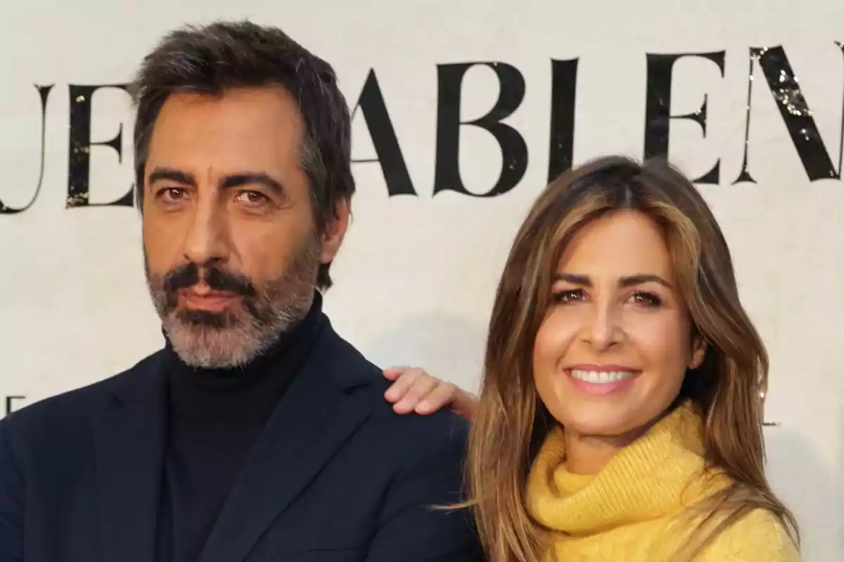 Nuria Roca sonriente con su mano sobre el hombro de Juan del Val con barba y expresión seria, ambos posando frente a un fondo con texto.